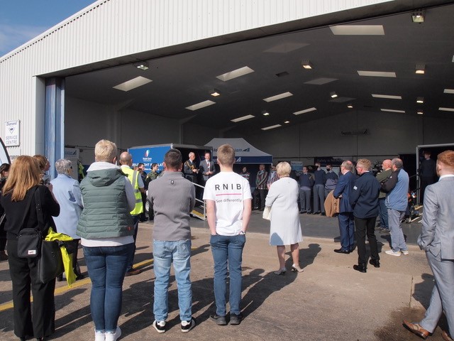 Public gathered outside hangar.